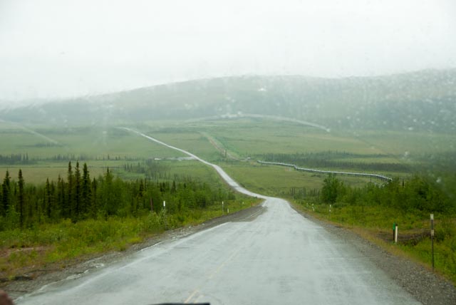 A view of the Dalton Highway and the Alaska Pipeline on a dreary day
